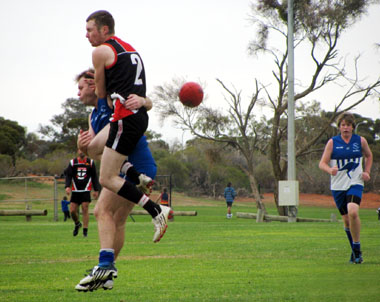 A tackle involving Jack Burns and Andamooka player, with Kendall Plant in the background