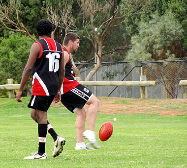 Ben Buller kicking for goal with Timmy Walker  watching