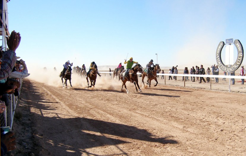 Kingston Sea emerges from the dust filled track carrying jockey Garry Burchmore past the post to his third Coober Pedy Opal Inn Cup win