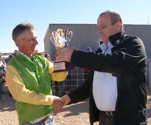 Winning Jockey Garry Burchmore received his trophy from Robert Coro of the Opal Inn